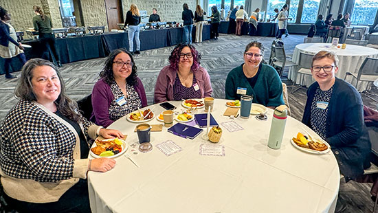 several women seating around the table and smiling in community