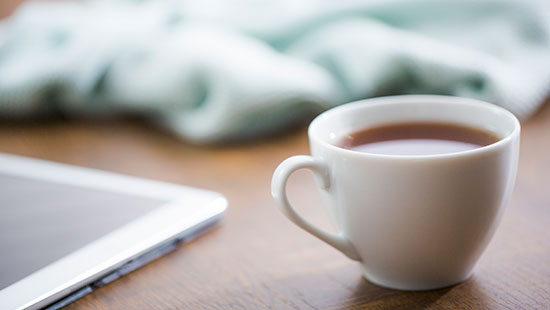 a cup of tea next to laptop; gear up for reading!